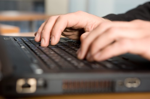 Hände einer Person liegen auf der Tastatur. Les doigts d'une personne sur le clavier. Le mani di una persona sulla tastiera.